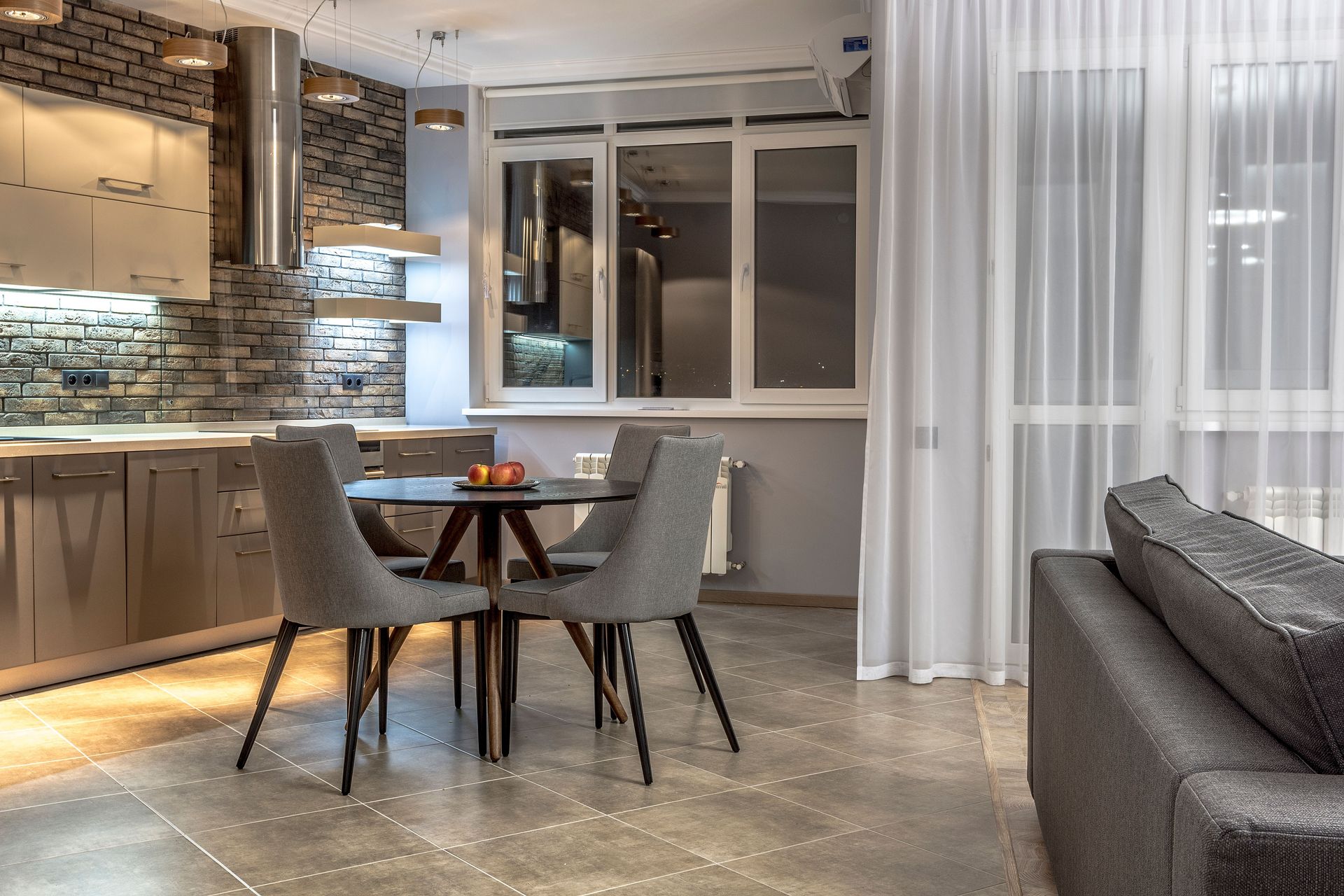 Stylish open plan apartment featuring sleek kitchen, dining, and living areas with modern furnishings.